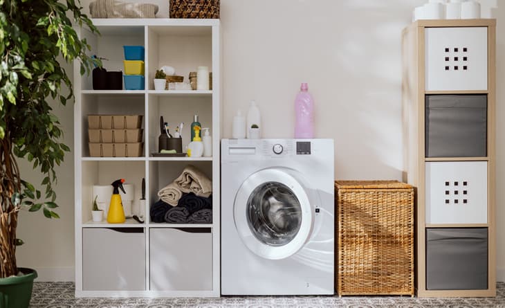 lavanderia com armários e máquina de lavar